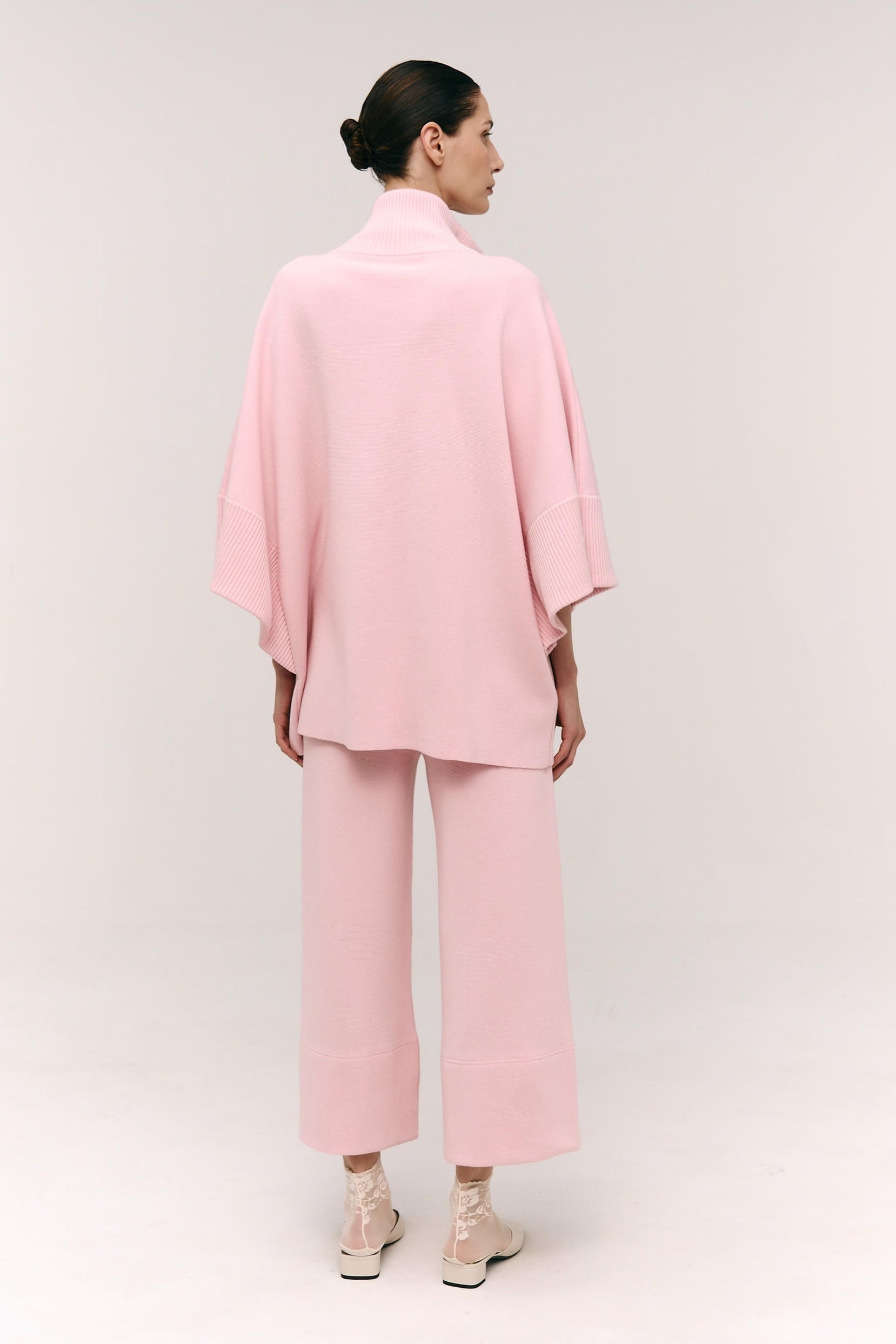 Person wearing a pink outfit on a white background