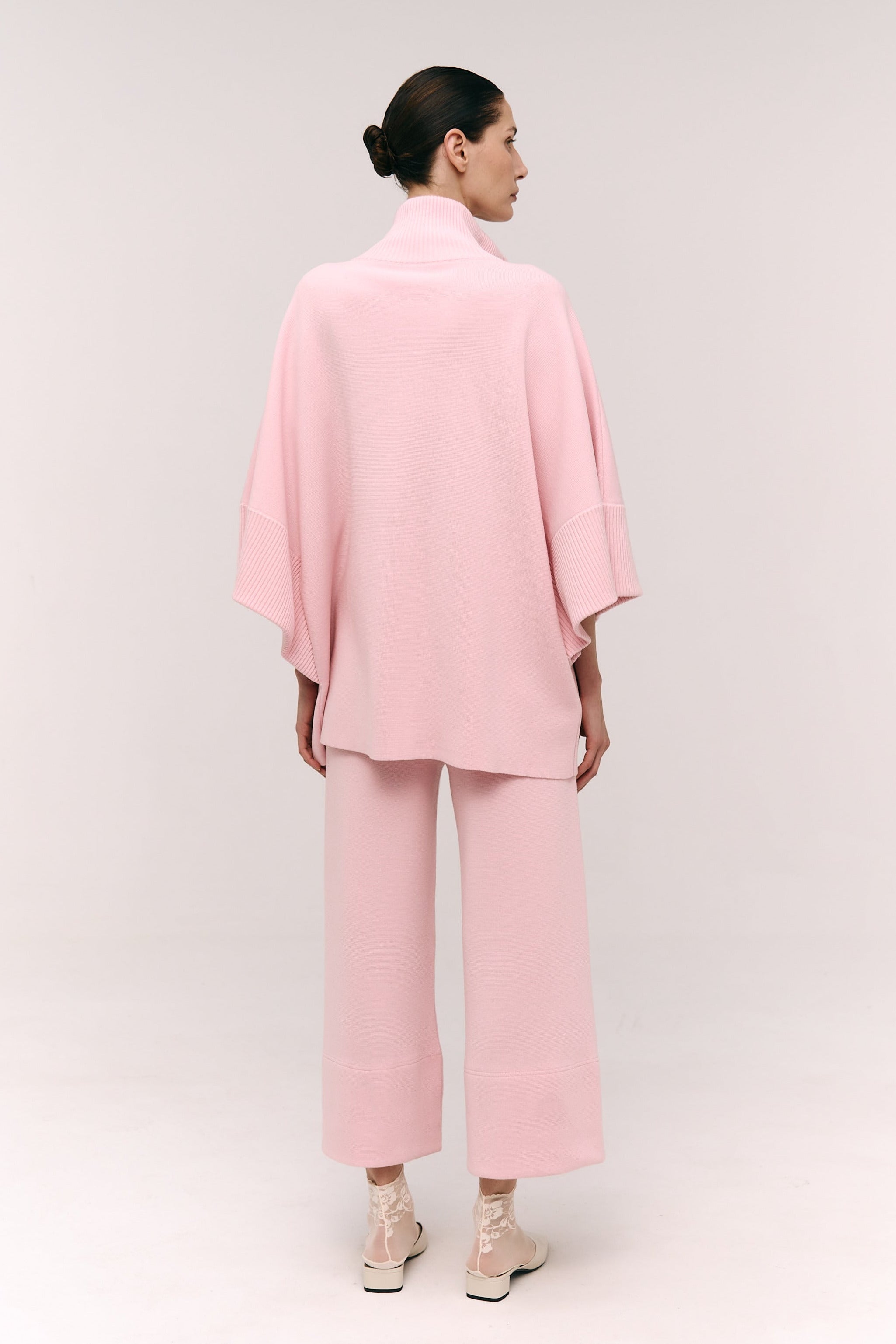 Person wearing a pink outfit on a white background