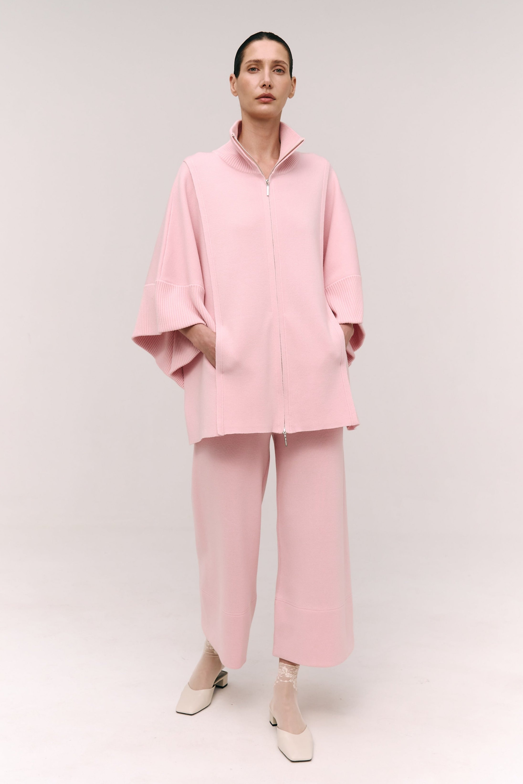 Person wearing a pink outfit on a white background