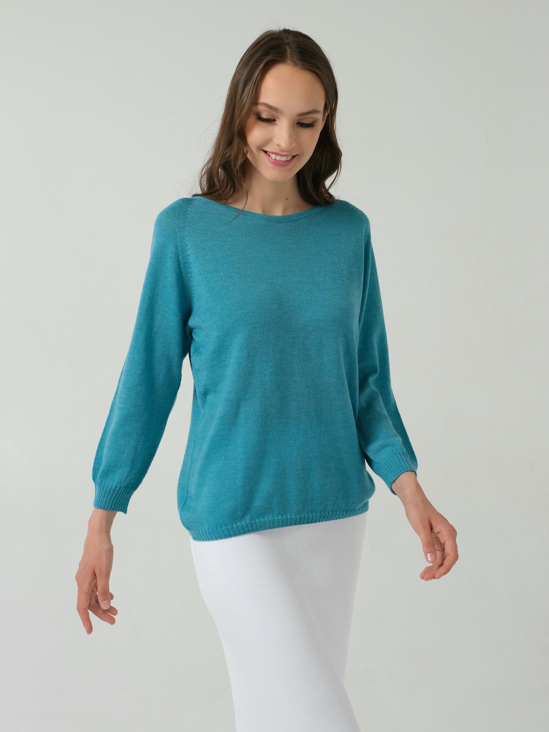A long-sleeved pink merino wool jumper with a round neckline, displayed against a white background.