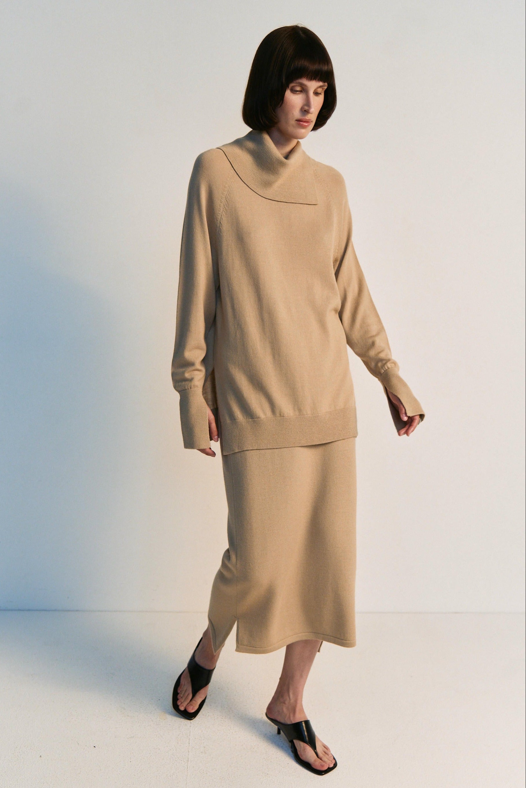 Woman wearing a beige outfit on a white background