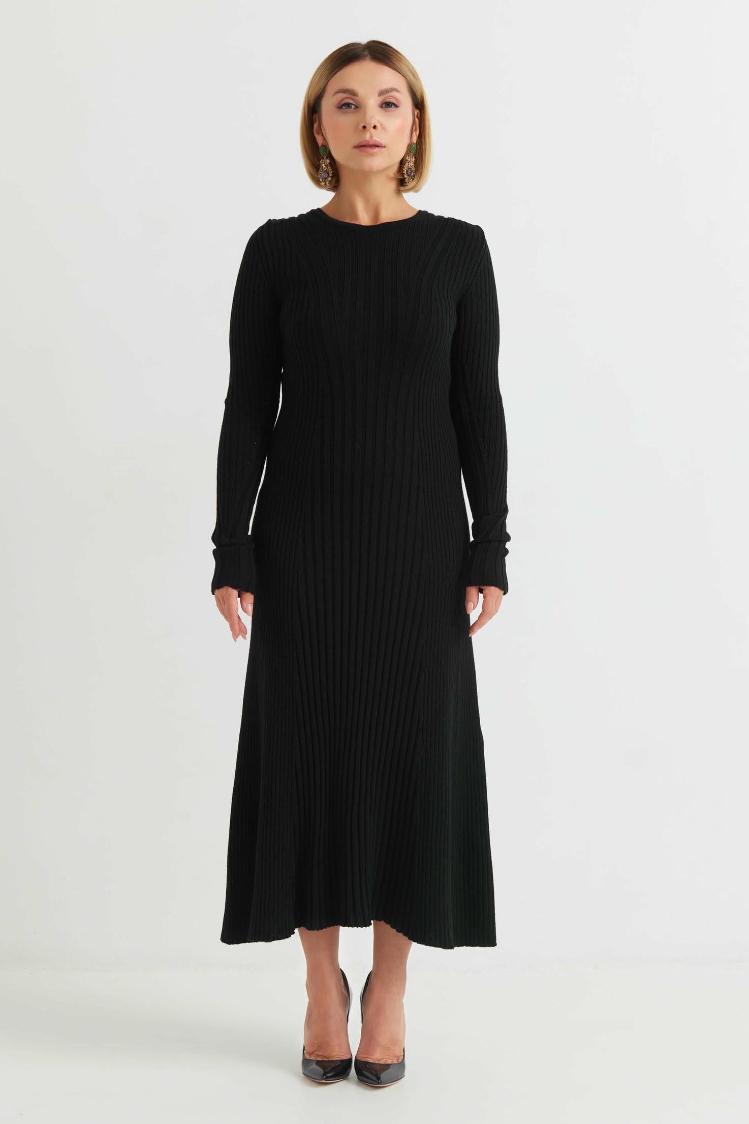 Woman wearing a black ribbed dress on a white background