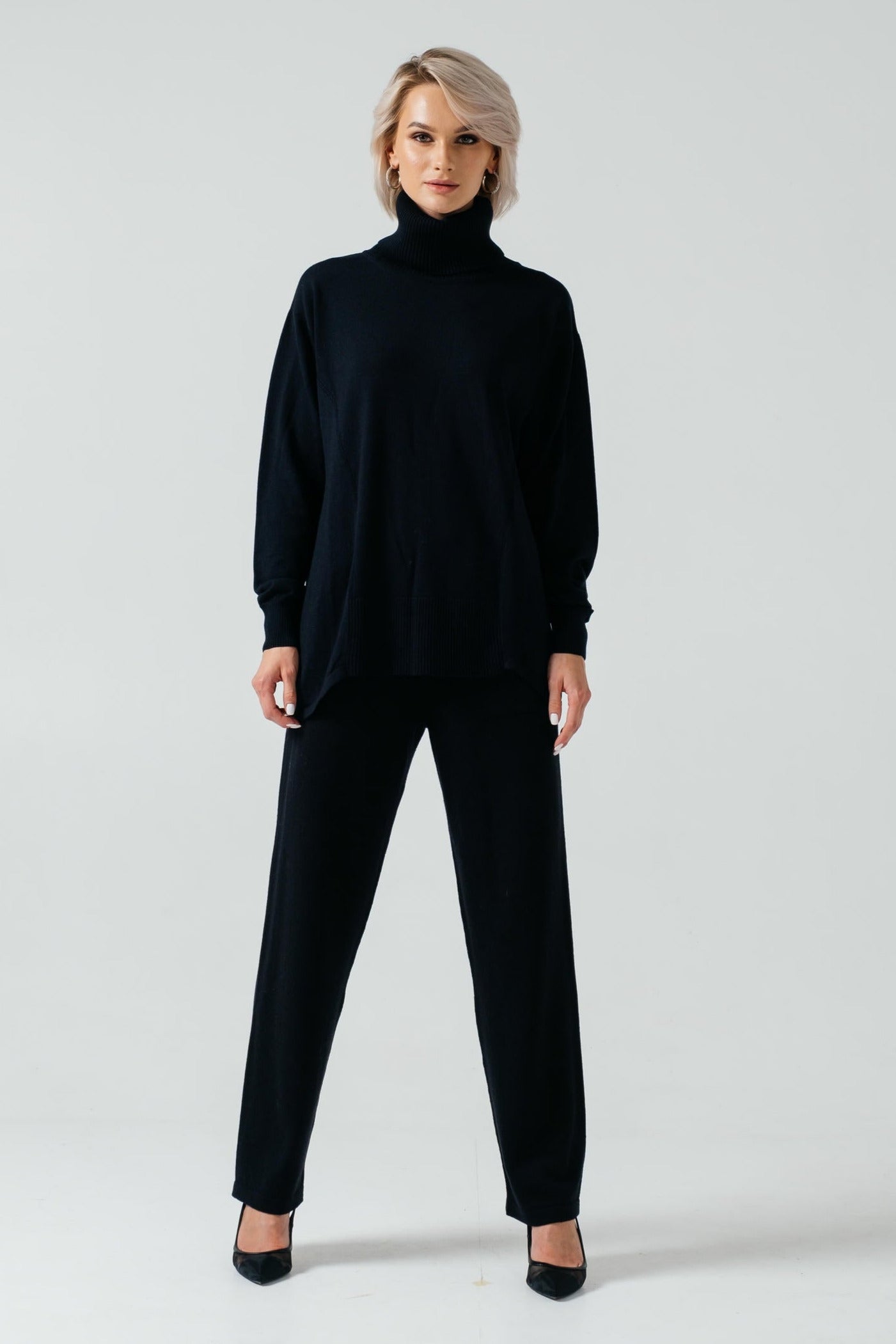 Woman wearing a black turtleneck and pants on a white background