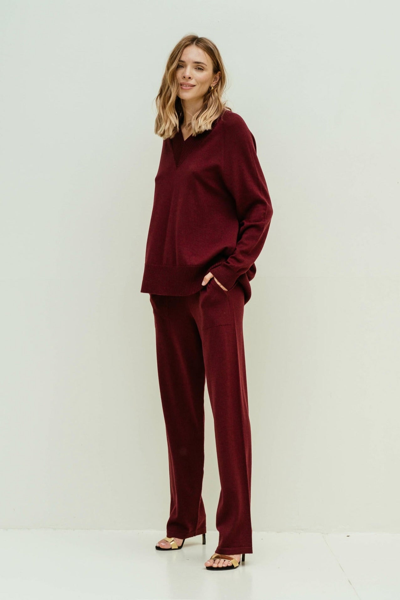 Woman wearing a burgundy outfit on a white background
