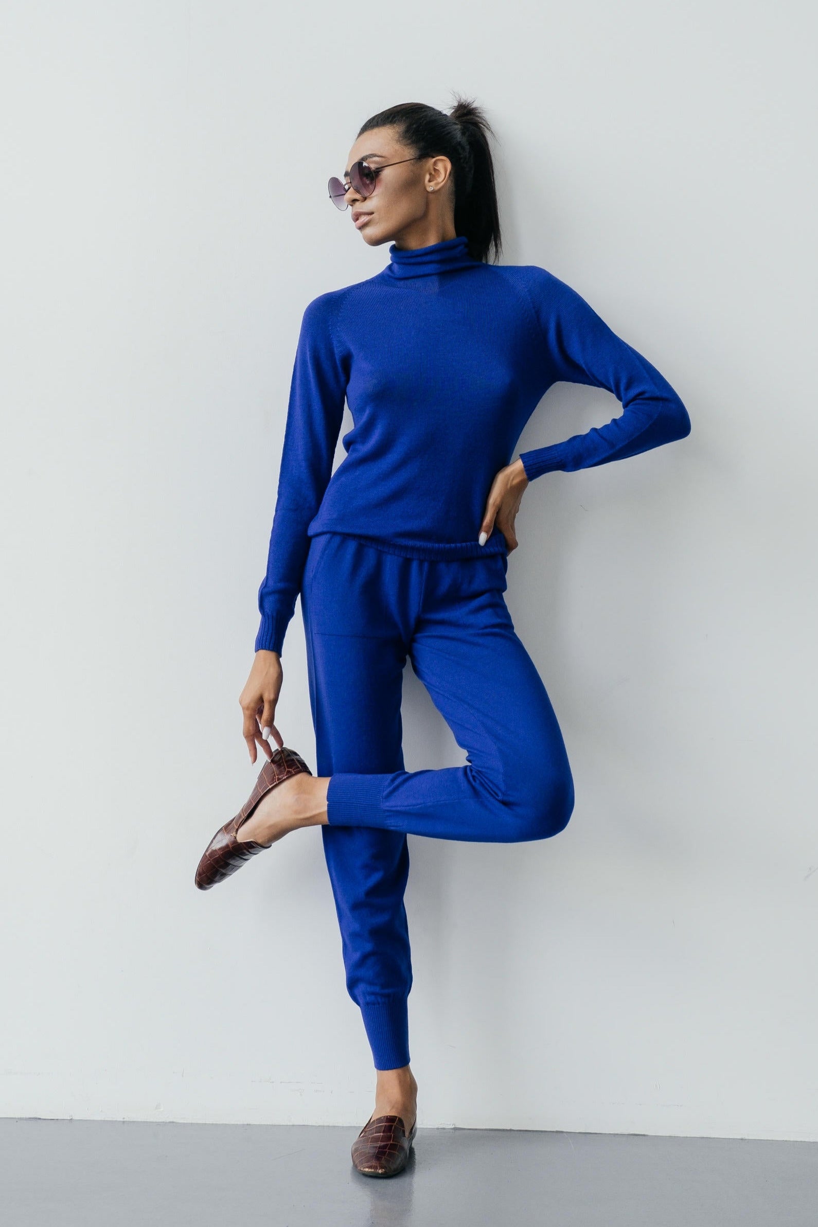 Woman wearing a blue outfit against a white background