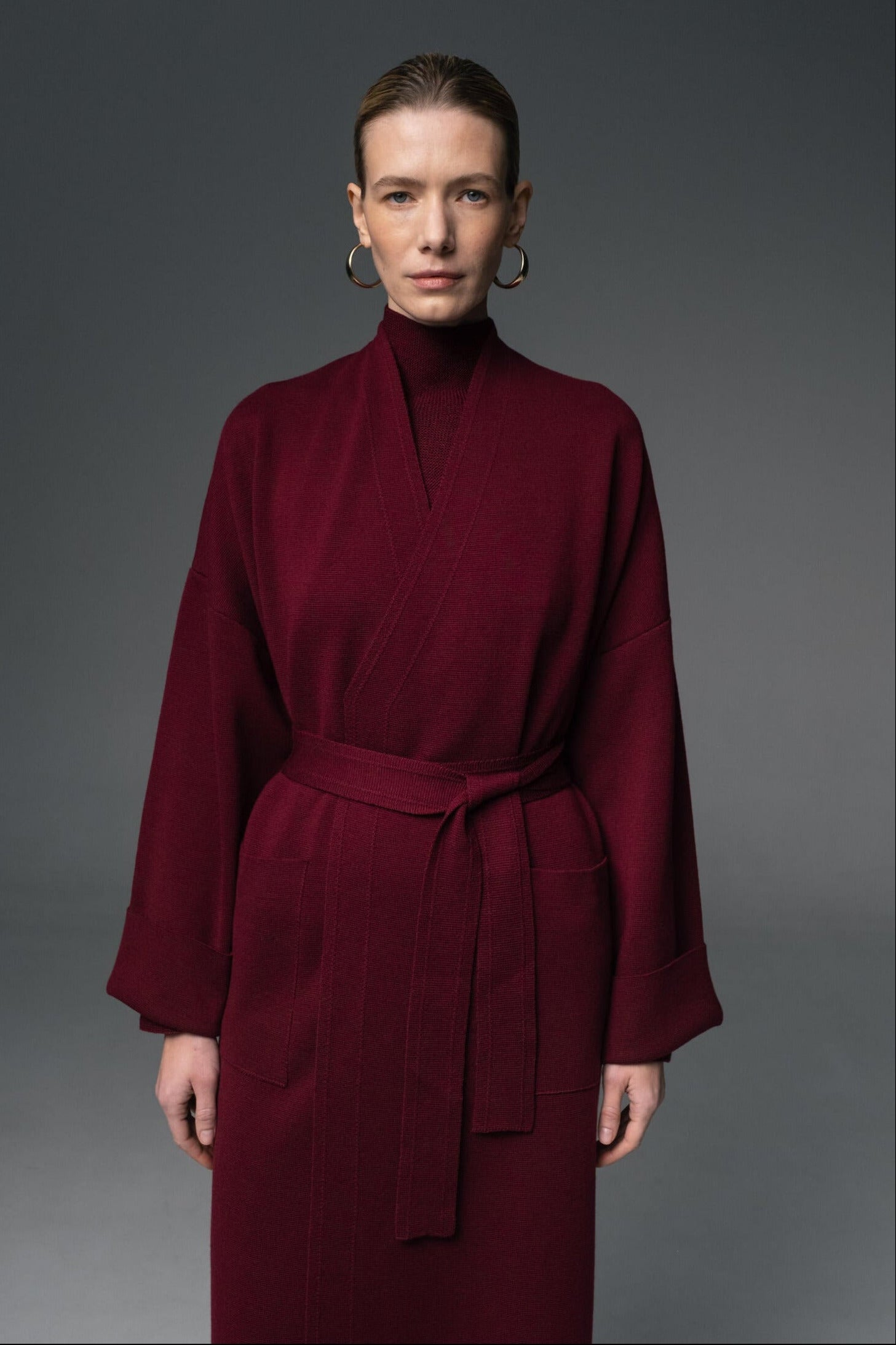 Woman wearing a burgundy dress against a gray background