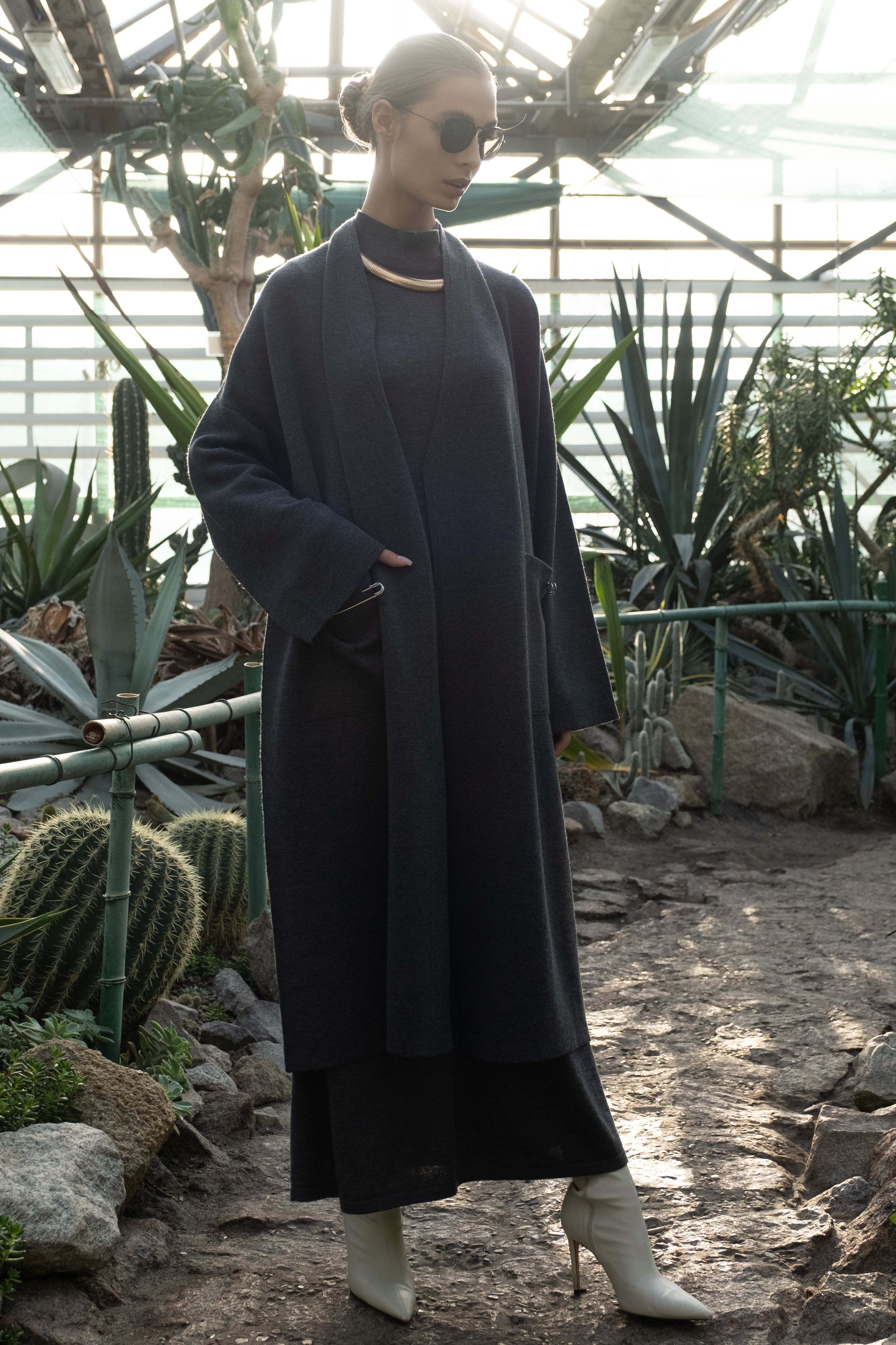 A graphite merino wool coat with a belt, designed with wide sleeves and a V-neckline, displayed against a plain background.