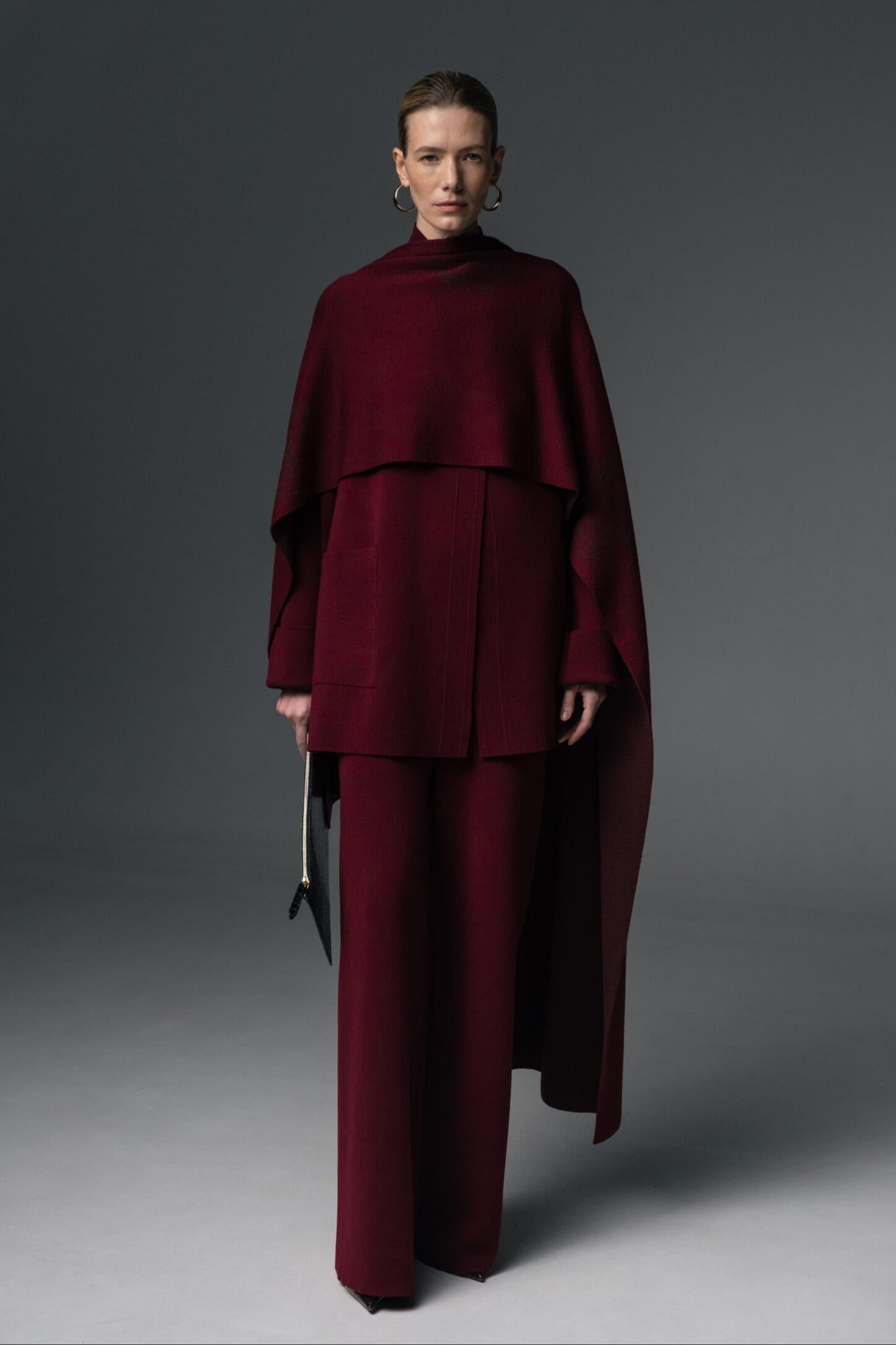 Person wearing a burgundy outfit against a gray background