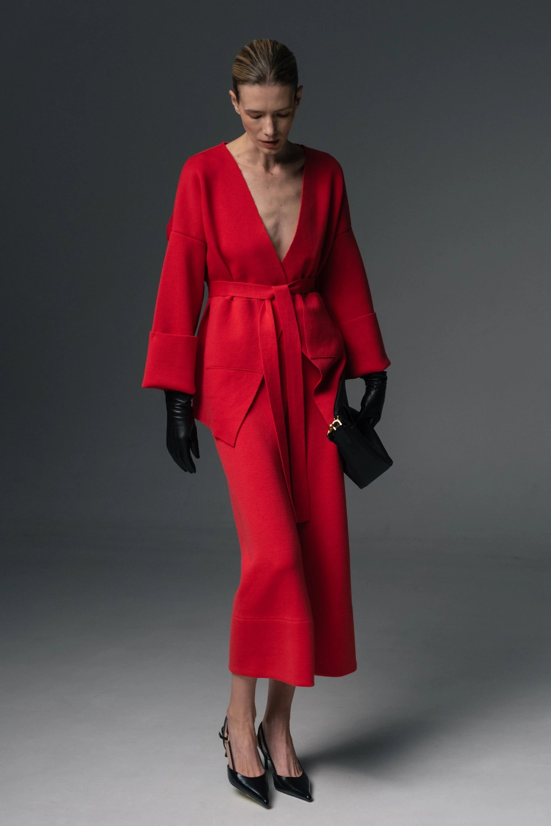 Model wearing a red dress on a gray background