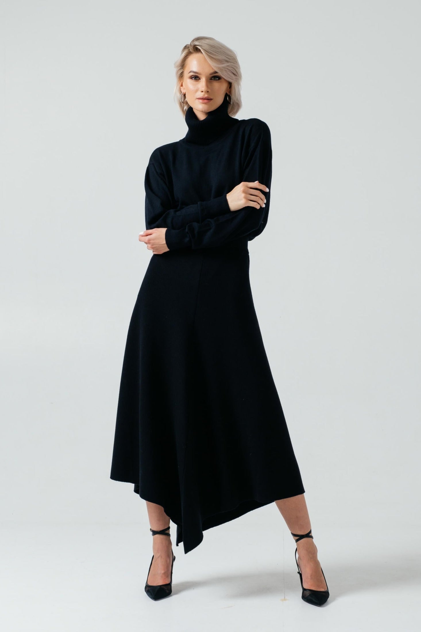 Woman wearing a black dress with a high neckline on a white background