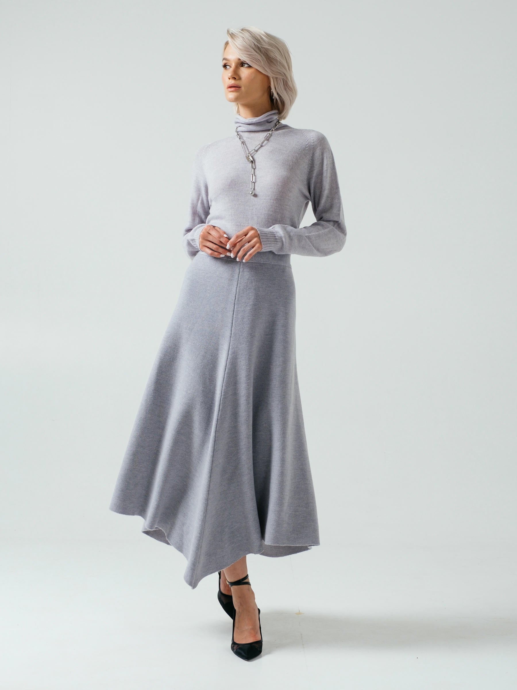 Woman wearing a gray dress on a plain background