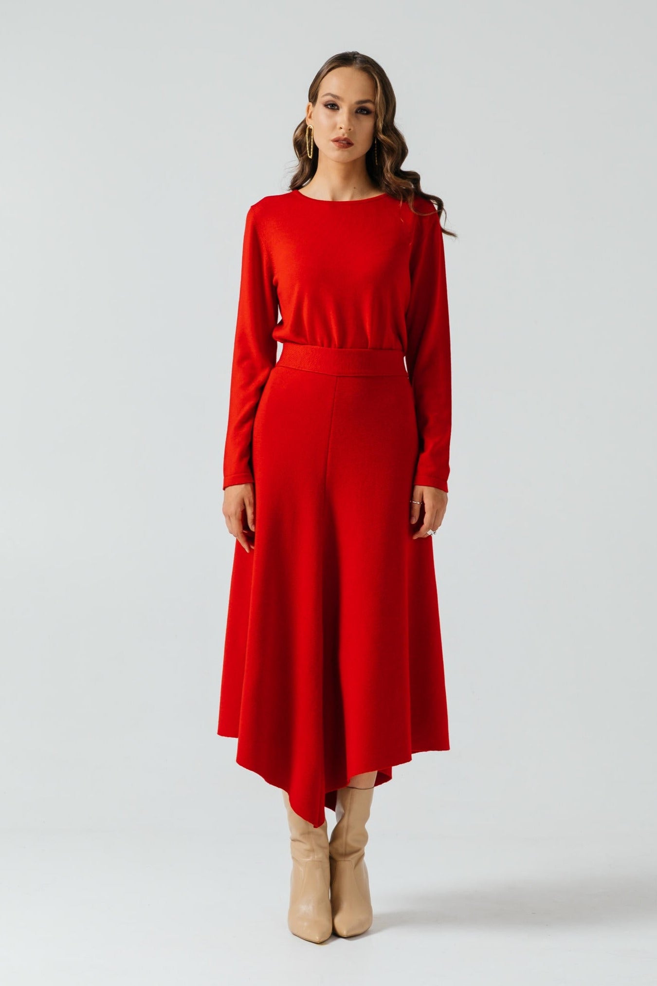 Woman wearing a red dress with long sleeves on a white background