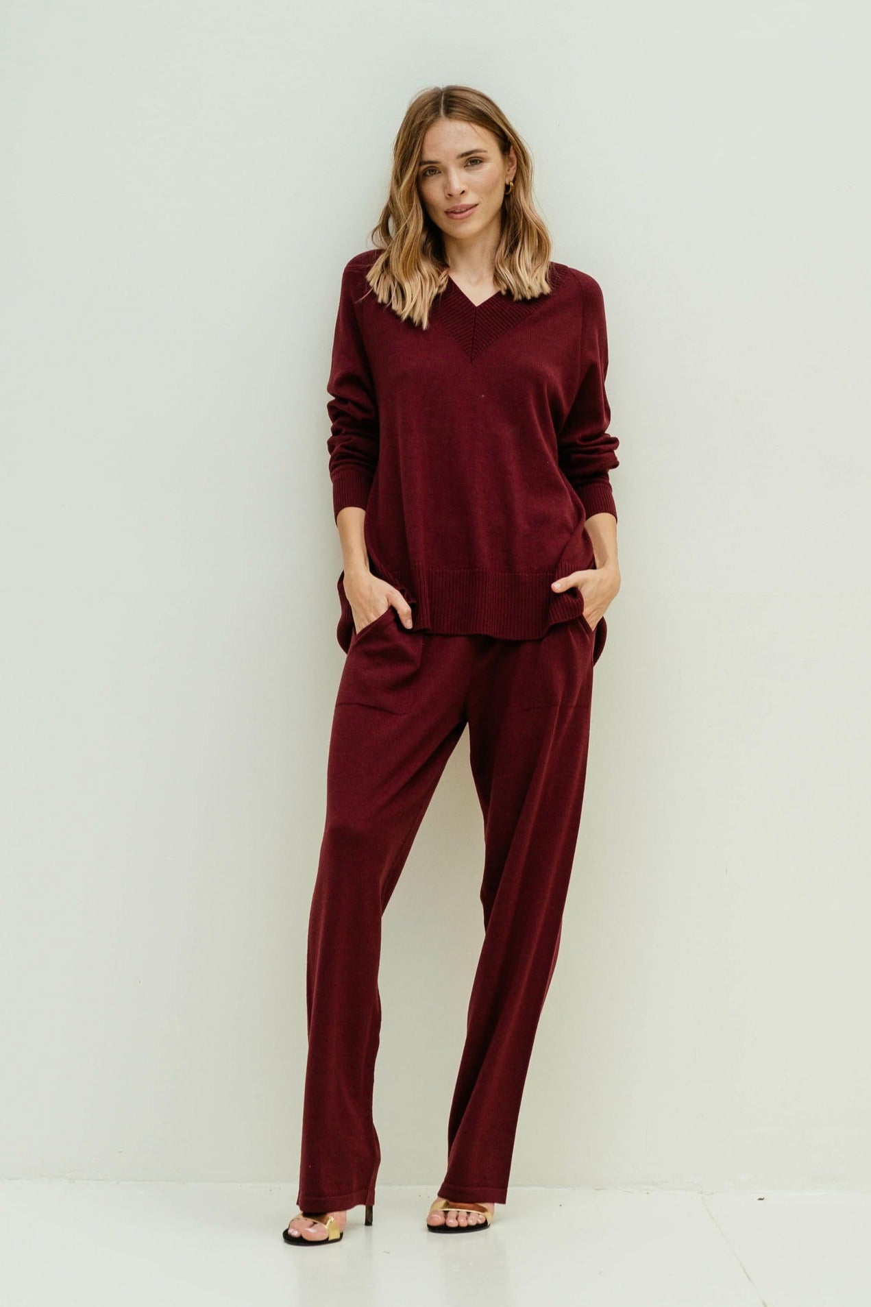 Woman wearing a burgundy outfit against a white background