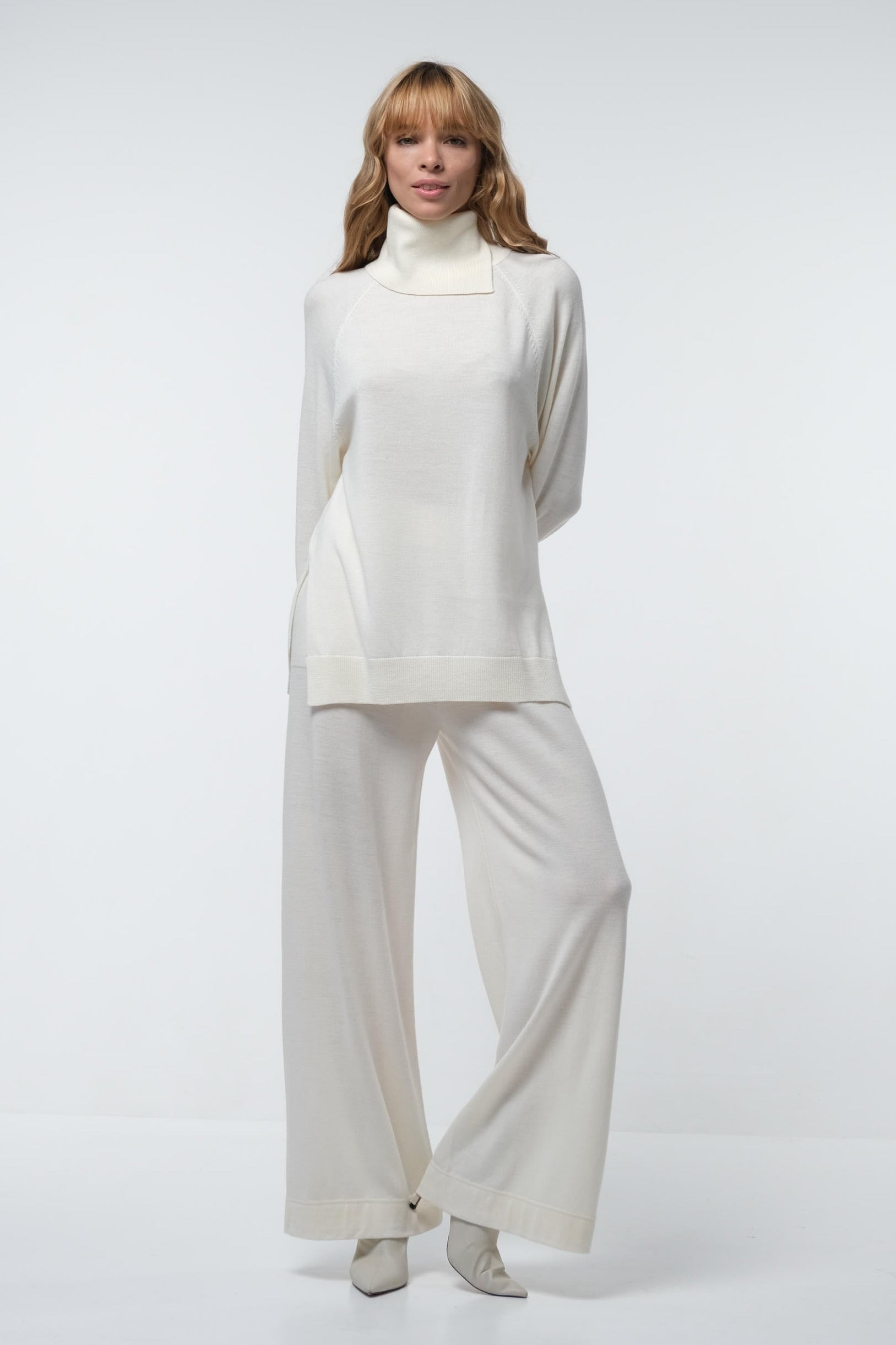 Person wearing a white outfit on a light gray background