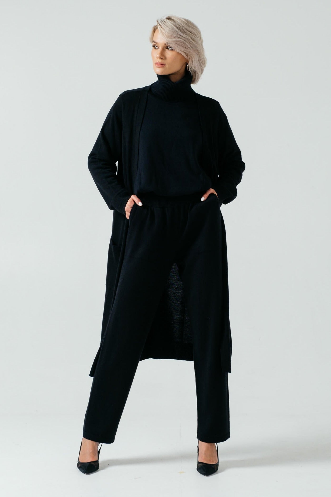 A pair of black, slim-fit, elastic waistband merino wool pants with no visible pockets.