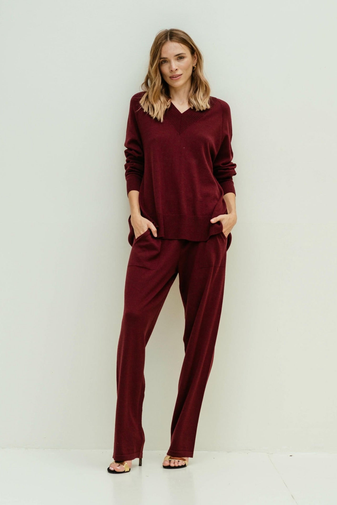 Woman wearing a burgundy outfit against a white background