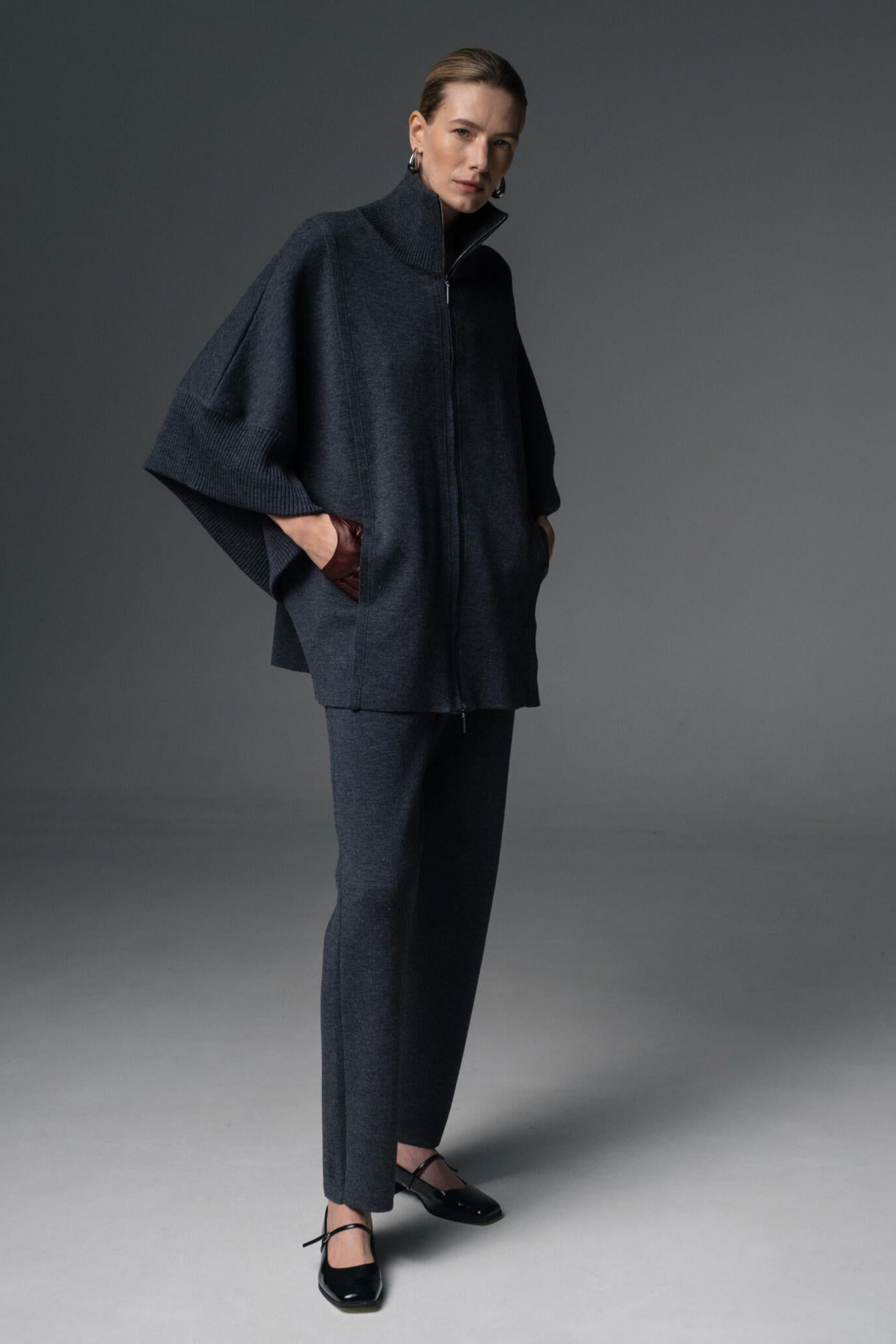 Person wearing a dark blue outfit on a gray background