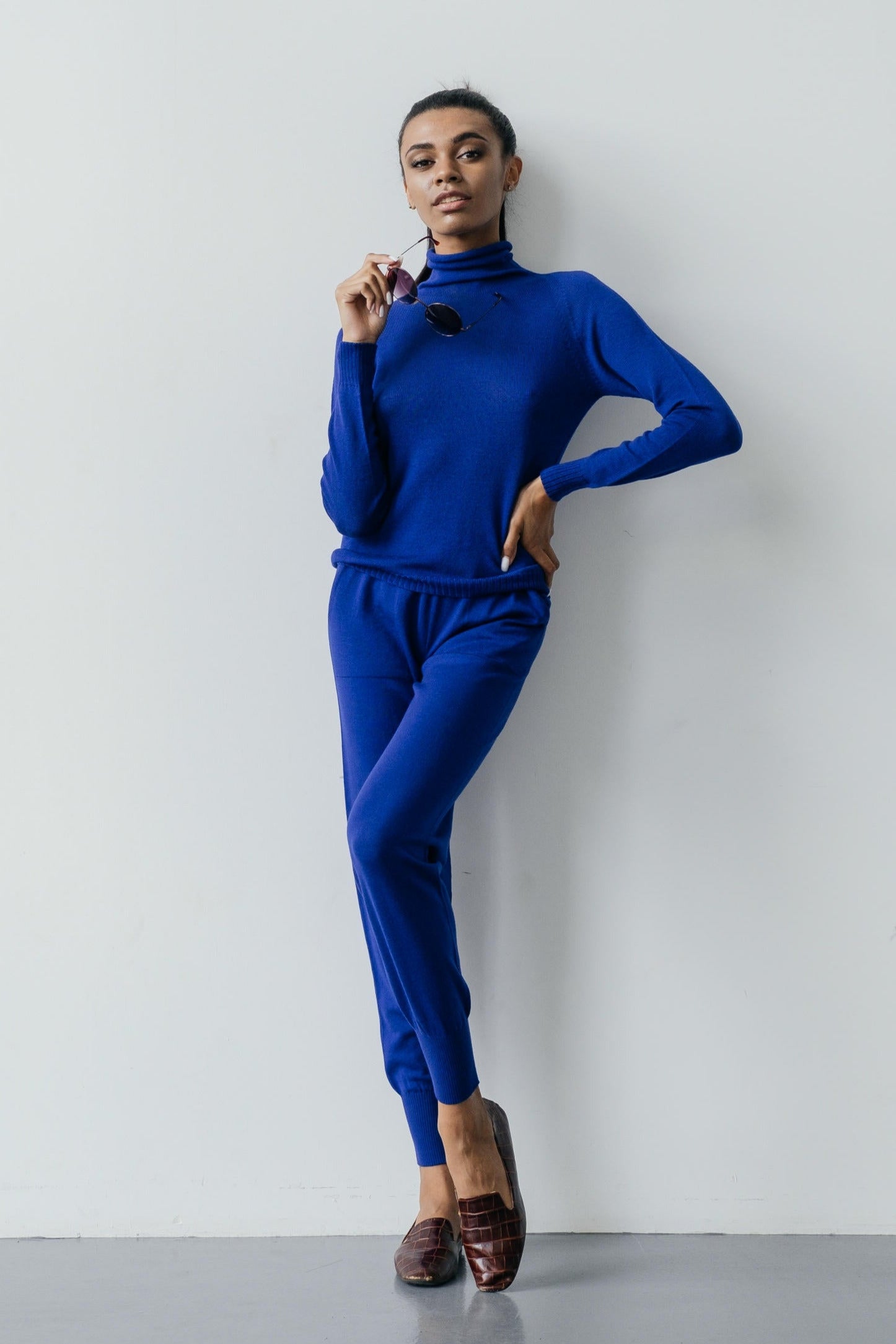 Woman wearing a blue outfit against a white background