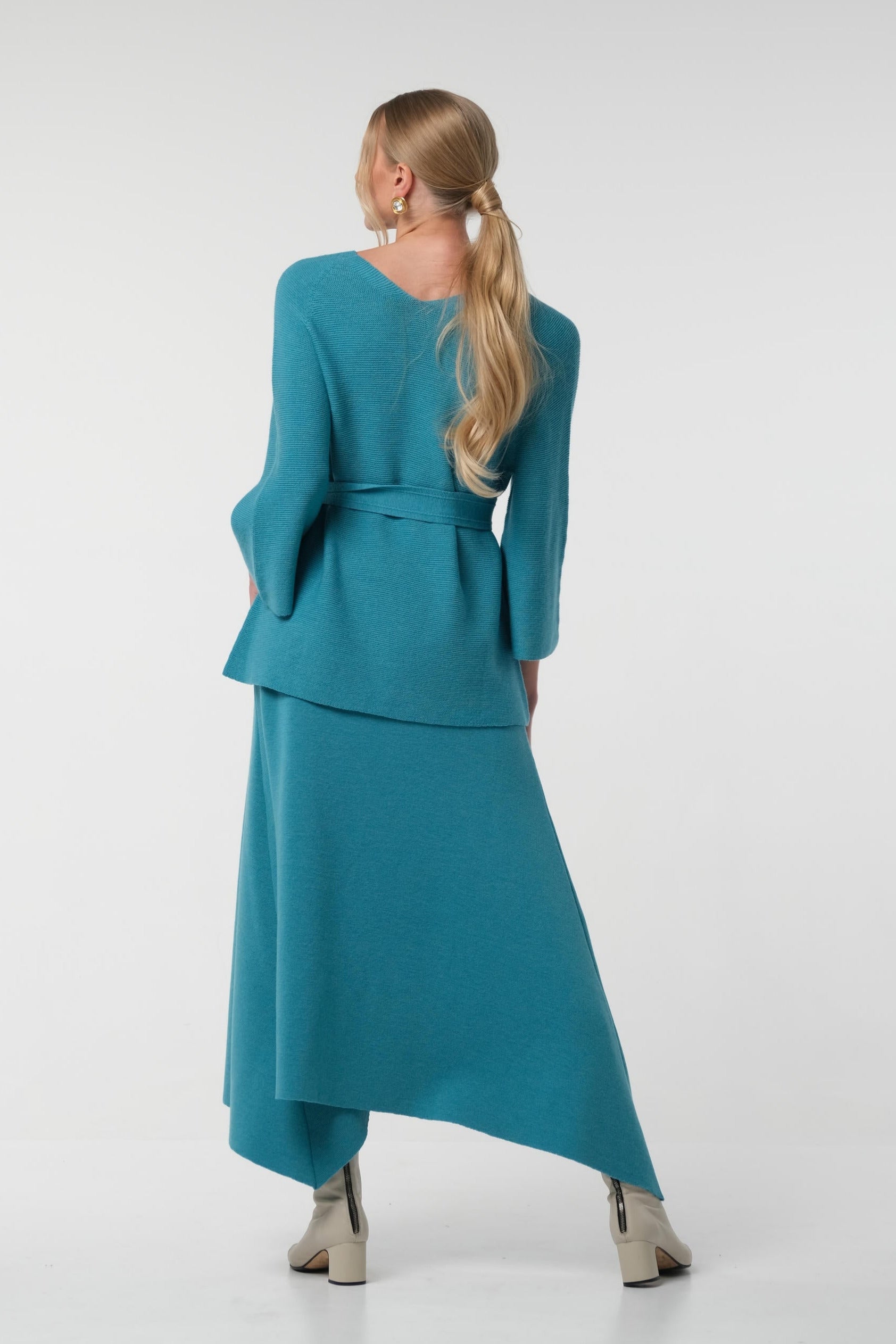 Woman wearing a teal outfit on a white background