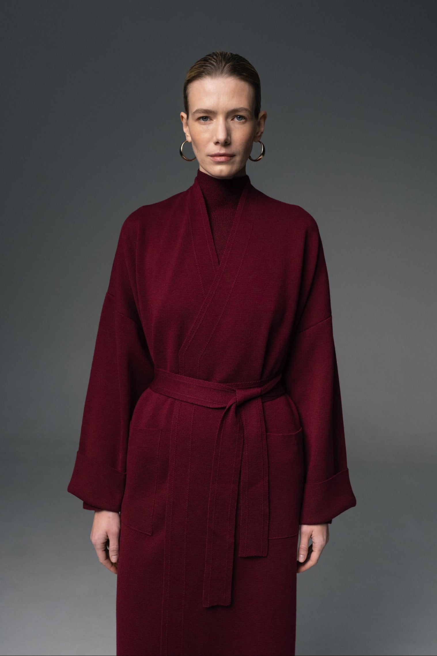 Woman wearing a burgundy dress against a gray background