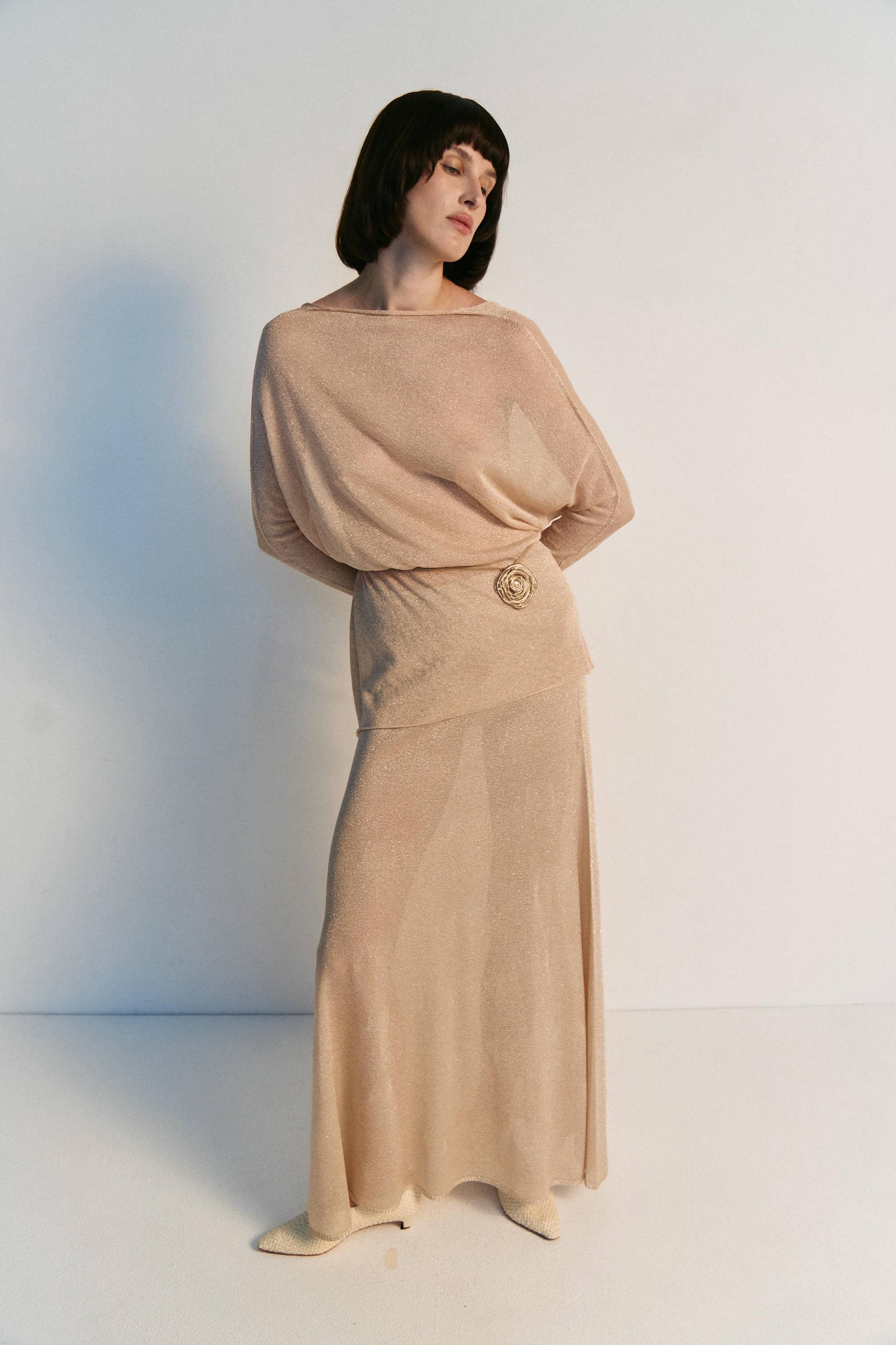 Woman wearing a beige dress with a plain background