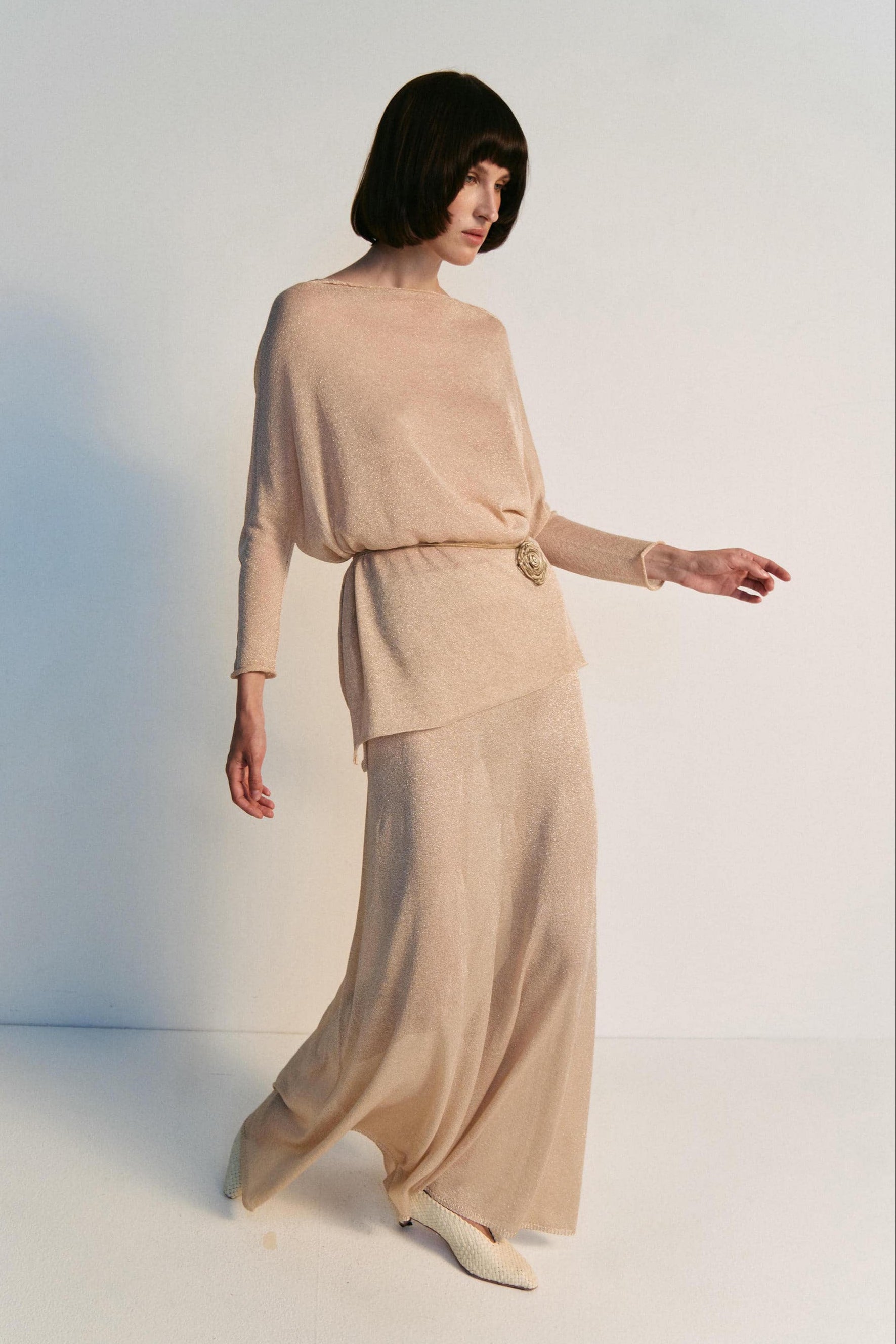Woman wearing a beige outfit on a white background